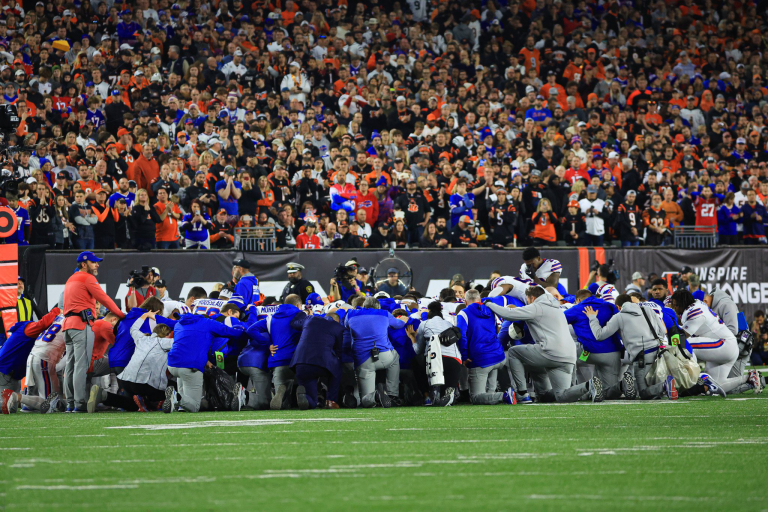Buffalo Bills players pray for Damar Hamlin after he collapsed on the field.