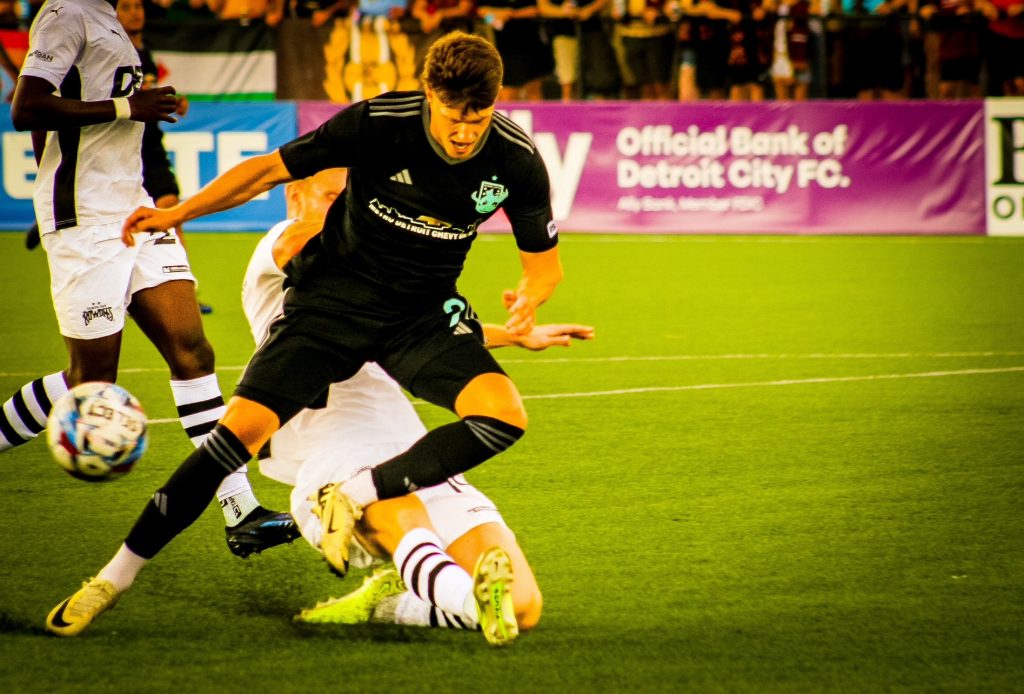 Rhys Williams of Detroit City FC tries to stave off a Tampa Bay Rowdies defender.