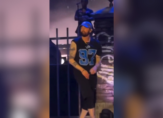 Eminem wears an Aidan Hutchinson jersey onstage at a show Eminem wearing a Lions Aidan Hutchinson jersey.